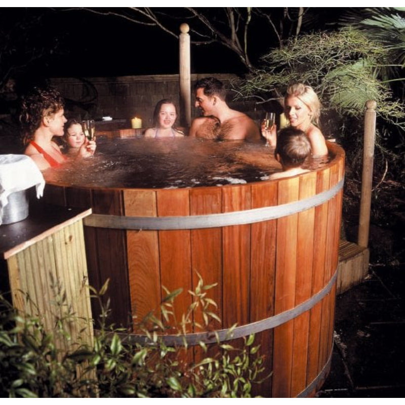 Family enjoying Cedar Hot Tub in Backyard at night.