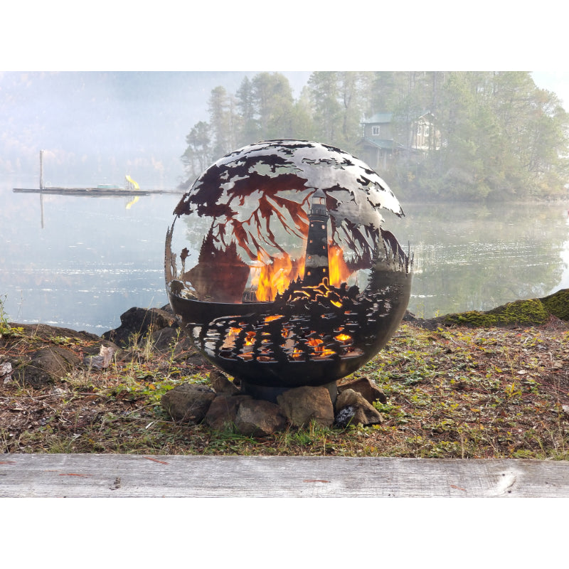 West Coast Fire Pit Sphere with fire next to a lake